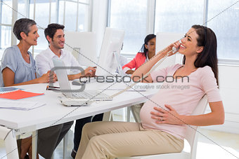 Businesswoman on the phone and strokes preganat belly