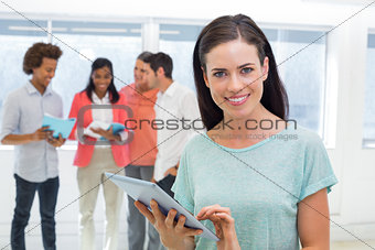 Businesswoman using tablet and smiling at camera