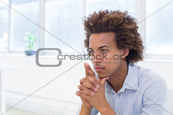 Attractive businessman thinking with hands together