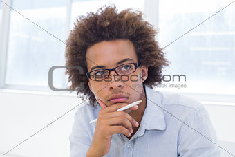 Attractive businessman thinking and holding a pencil