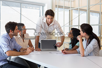 Attractive businessman speaking to coworkers
