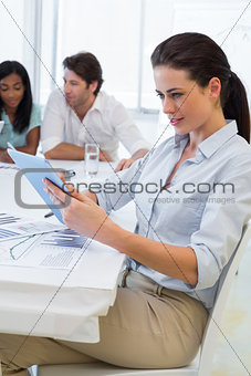 Pretty businesswoman using tablet device in business meeting