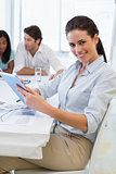Pretty businesswoman using tablet device in business meeting