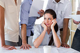 Worried businesswoman surrounded by colleagues