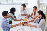 Business people chat while eating muffins and drinking coffee