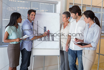 Businessman explaining graph to coworkers
