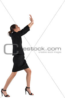 Businesswoman in suit standing and pushing up