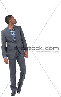 Serious businessman stepping ahead and looking up