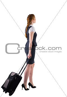 Redhead businesswoman pulling her suitcase