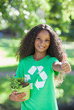 Young environmental activist smiling at the camera holding a potted plant