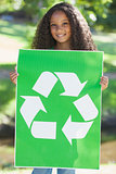 Young environmental activist smiling at the camera holding a poster
