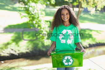 Young environmental activist smiling at the camera holding box