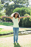 Young girl smiling with arms outstretched in the park