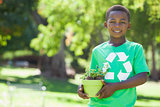 Young boy in recycling tshirt holding potted plant
