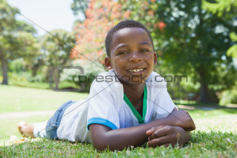 Little boy lying in the park smiling at camera