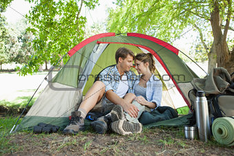 Cute couple sitting in their tent showing affection