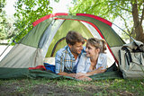 Cute couple lying in their tent smiling at each other