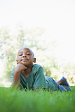 Little boy lying on grass smiling at camera