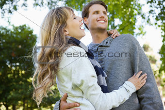Cute couple embracing and laughing in the park