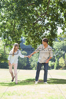 Carefree couple standing in the park holding hands