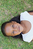 Little girl lying on the grass smiling at camera