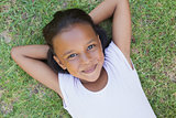 Little girl lying on the grass smiling at camera