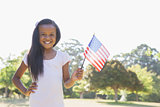 Little girl smiling at camera waving american flag