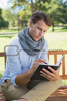 Stylish young man writing in his notepad