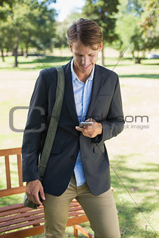 Casual businessman texting on smartphone in park