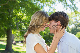 Cute couple hugging and smiling at each other in the park