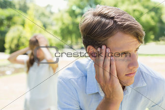 Upset man thinking after a fight with his girlfriend in the park
