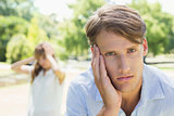 Upset man looking at camera after a fight with his girlfriend in the park