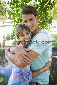 Close young couple standing together in the park smiling at camera
