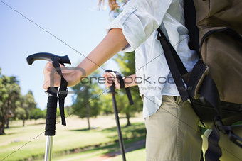 Fit woman walking with hiking pole in park