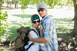 Active cute couple embracing each other on a hike smiling at camera