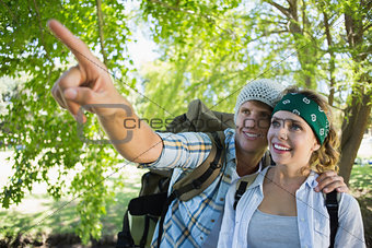 Active couple on a hike with man pointing
