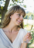 Cute blonde sitting outside toasting with champagne