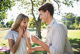 Man surprising his girlfriend with a proposal in the park