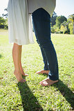 Couples bare feet standing on grass