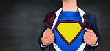 Composite image of businessman opening shirt in superhero style