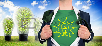 Composite image of businessman opening shirt in superhero style