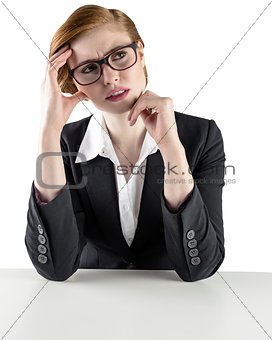 Thinking redhead businesswoman looking puzzled