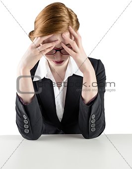 Redhead businesswoman with head in hands