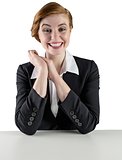 Excited redhead businesswoman sitting at desk