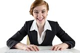 Excited redhead businesswoman sitting at desk