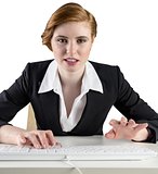 Redhead businesswoman sitting at desk typing