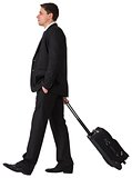 Handsome businessman pulling his suitcase