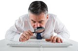 Mature businessman examining with magnifying glass