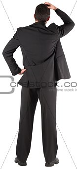 Businessman standing back to the camera with hand on head