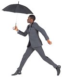 Businessman walking and holding umbrella